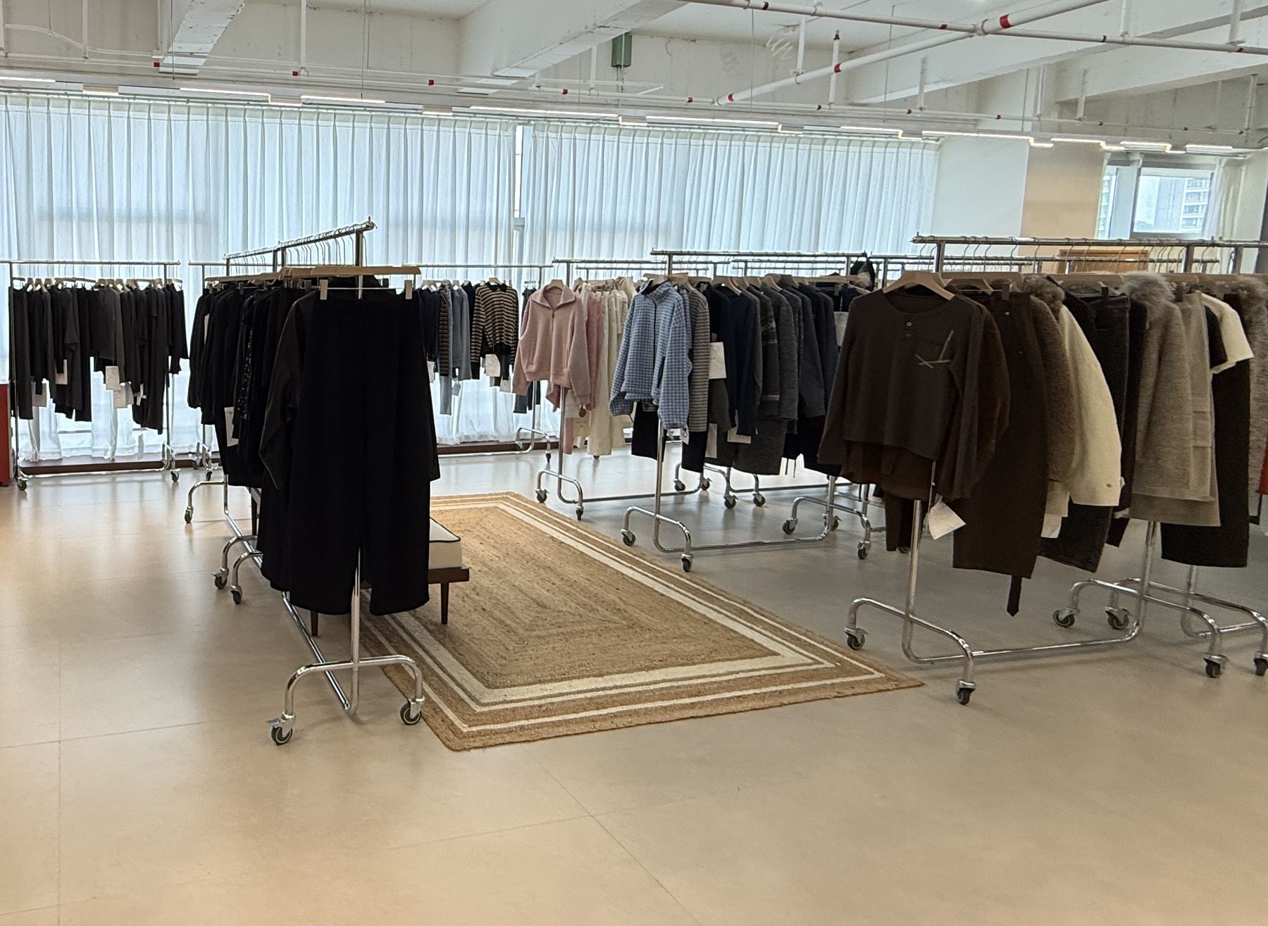 The N.R.E. showroom: rails of knitwear, tailoring and outerwear samples